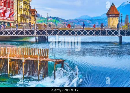 LUZERN, SCHWEIZ - 30. MÄRZ 2022: Nadeldamm und schnell fließender Reuss, am 30. März in Luzern, Schweiz Stockfoto