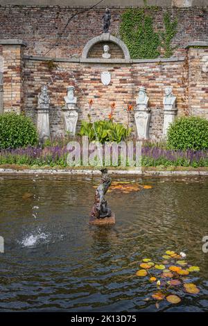 Wicklow, Irland, 2019. August Triton-Statue und Brunnen auf einem kleinen Teich mit Büstenskulpturen in den Powerscourt-Gärten, Enniskerry Stockfoto