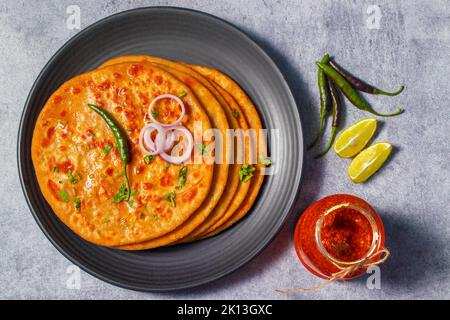 Berühmtes nordindisches Essen Aloo Paratha mit Mangobeike und Butter. Stockfoto