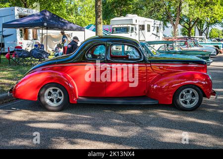 Falcon Heights, MN - 18. Juni 2022: Hochperspektivische Seitenansicht eines Ford Deluxe Flathead V8 Coupés aus dem Jahr 1940 auf einer lokalen Automobilausstellung. Stockfoto