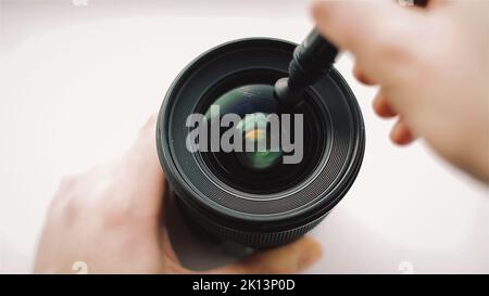 Anfangend Fotograf oder Video-Kameramann ist sorgfältig Reinigung der vorderen Glas des Objektivs. Stockfoto