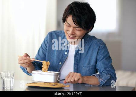 Japanischer Mann, der zu Hause isst Stockfoto