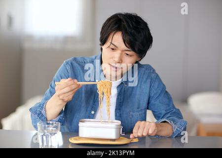 Japanischer Mann, der zu Hause isst Stockfoto