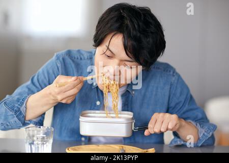 Japanischer Mann, der zu Hause isst Stockfoto