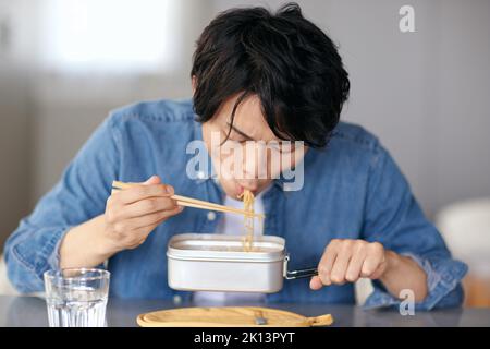 Japanischer Mann, der zu Hause isst Stockfoto