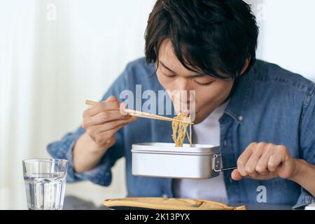 Japanischer Mann, der zu Hause isst Stockfoto