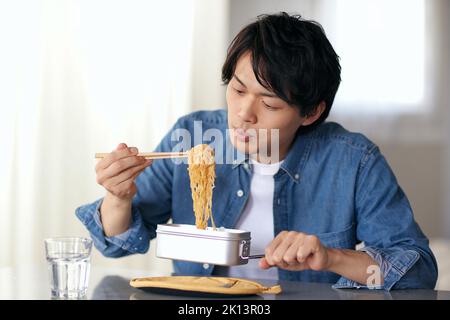 Japanischer Mann, der zu Hause isst Stockfoto