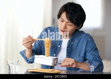 Japanischer Mann, der zu Hause isst Stockfoto