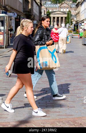 Dundee, Tayside, Schottland, Großbritannien. 15. September 2022. UK Wetter: Aufgrund der warmen Septembersonne erreichten die Temperaturen im Nordosten Schottlands 16 Grad Eine Woche vor dem Herbst sind trendige Frauen im Stadtzentrum von Dundee unterwegs, genießen das angenehme warme Wetter und gehen beim Einkaufen ihre Geschäfte durch. Kredit: Dundee Photographics/Alamy Live Nachrichten Stockfoto