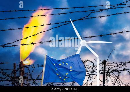 Industriegasanlage hinter Stacheldrahtzaun und EU-Flagge mit gebrochener Windenergieanlage. Energiekrise, Russland, Ukraine-Konflikt, erneuerbare Energien, fossile Brennstoffe Stockfoto