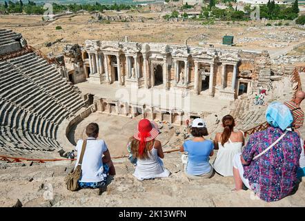 Unbekannte Touristen besuchen das antike Theater der römischen Stadt Hierapolis in Pamukkale, Türkei. Stockfoto