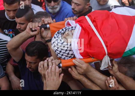 Jenin, Palästina. 15. September 2022. (ANMERKUNG DER REDAKTION: Das Bild zeigt den Tod)Trauernde tragen den Leichnam des Salah17-jährigen Odai, der von israelischen Armeekräften während der Zusammenstöße im Dorf Kafr Dan, der östlichen Stadt Jenin am Westufer, getötet wurde. Kredit: SOPA Images Limited/Alamy Live Nachrichten Stockfoto