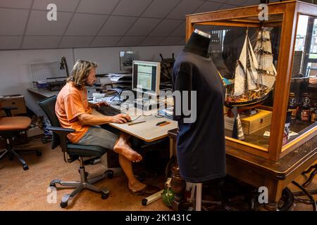 Kapitän Andreas Lackner, Gründer der Reederei 'Fairtransport', hier in seinem Büro im Heimathafen in Den Helder Niederlande. Hier wird sie von der Besatzung auf ihre nächste Reise vorbereitet. Der Schoner Tres Hombres transportiert Waren wie Wein, Kaffee, Schokolade und Rum aus der Karibik über den Atlantik nach Europa auf völlig klimaneutrale Weise. Stockfoto