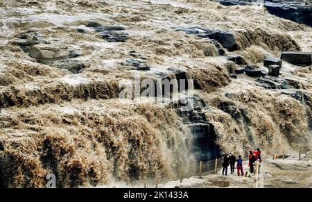 Yan'an. 15. September 2022. Touristen sehen die Landschaft des Hukou-Wasserfalls am Gelben Fluss in der nordwestlichen chinesischen Provinz Shaanxi, 15. September 2022. Der Hukou-Wasserfall erlebt in letzter Zeit einen zunehmenden Wasserfluss. Quelle: Tao Ming/Xinhua/Alamy Live News Stockfoto