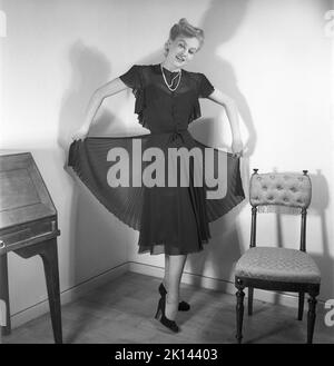 Damenmode im Jahr 1940s. Eine junge Frau, die für ein Damenmagazin fotografiert wurde, um die Damenmode von 1945 zu zeigen. Das weibliche Model trägt ein schwarzes Abendkleid in verschiedenen Stoffschichten. Schweden 1945. Kristoffersson Ref. R2-4 Stockfoto