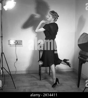 Damenmode im Jahr 1940s. Eine junge Frau, die für ein Damenmagazin fotografiert wurde, um die Damenmode von 1945 zu zeigen. Das weibliche Model trägt ein schwarzes Abendkleid in verschiedenen Stoffschichten. Schweden 1945. Kristoffersson Ref. R2-6 Stockfoto