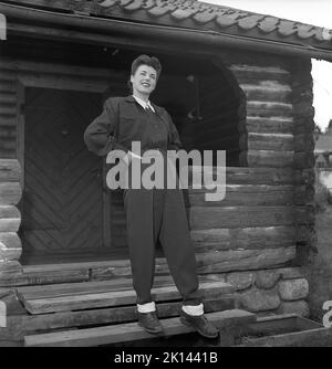 Damenmode im Jahr 1940s. Eine junge Frau, die für ein Damenmagazin fotografiert wurde, um die Damenmode von 1945 zu zeigen. Das weibliche Modell trägt die typische Sportkleidung der Zeit, die entweder beim Skifahren oder in der Freizeit getragen werden konnte. Die Hose ist aus dem typischen elastischen Synthetikgewebe mit einem daran befestigten Band gefertigt, das unter dem Fuß zu haben ist und so einen gestreckten Look erzeugt. Schweden 1945. Kristoffersson Ref. R6-1 Stockfoto