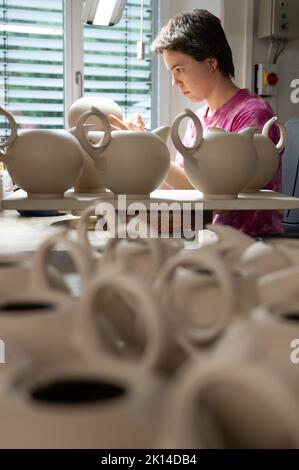 15. September 2022, Sachsen, Meißen: Elisa Kropfeld, Industriekerkeramikerin, inspiziert eine Teekannen in der Porzellanfabrik Meißen. Sachsens Wirtschaftsminister Durig besucht im Rahmen einer "Rohstofftour" verschiedene Kaolin-Bergbau- und -Verarbeitungsstationen im Freistaat. Foto: Sebastian Kahnert/dpa Stockfoto