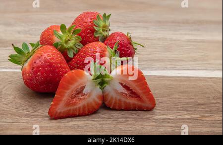 Frische Bio-Erdbeeren aus dem Garten auf einem Holzbrett zum Frühstück. Stockfoto