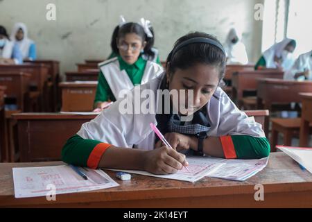 Dhaka, Bangladesch. 15. September 2022. Die Schüler sitzen für Secondary School Certificate (SSC) und gleichwertigen Prüfungen. Die öffentlichen Prüfungen begannen mit dem ersten Papiertest in Bangladesch in 3.790 Zentren im ganzen Land. Nach der Reduzierung der Prüfungsdauer auf zwei Stunden begannen die Tests um 11am Uhr und endeten um 1 Uhr. Aufgrund der Pandemie um drei Monate verzögert, sollten das Secondary School Certificate (SSC) und entsprechende Prüfungen im Juni abgehalten werden, aber die verheerenden Überschwemmungen kurz vor den Tests haben es weiter vorangetrieben. Kredit: SOPA Images Limited/Alamy Live Nachrichten Stockfoto