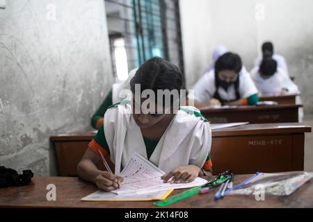 Dhaka, Bangladesch. 15. September 2022. Die Schüler sitzen für Secondary School Certificate (SSC) und gleichwertigen Prüfungen. Die öffentlichen Prüfungen begannen mit dem ersten Papiertest in Bangladesch in 3.790 Zentren im ganzen Land. Nach der Reduzierung der Prüfungsdauer auf zwei Stunden begannen die Tests um 11am Uhr und endeten um 1 Uhr. Aufgrund der Pandemie um drei Monate verzögert, sollten das Secondary School Certificate (SSC) und entsprechende Prüfungen im Juni abgehalten werden, aber die verheerenden Überschwemmungen kurz vor den Tests haben es weiter vorangetrieben. Kredit: SOPA Images Limited/Alamy Live Nachrichten Stockfoto