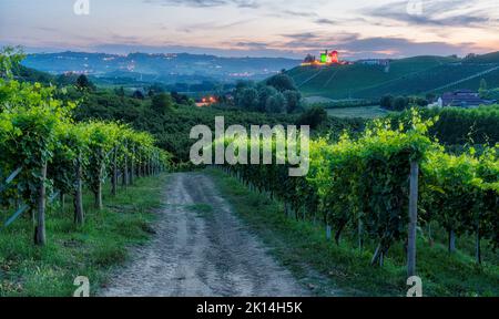 Eine schöne Landschaft mit dem Schloss Grinzane beleuchtet am Abend. Langhe Region Piemont, Cuneo, Norditalien. Stockfoto