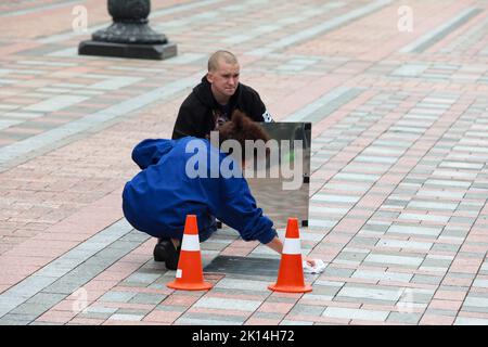 KIEW, UKRAINE - 15. SEPTEMBER 2022 - Ein Arbeiter wischt die Gedenktafel zu Ehren der Präsidentin der Europäischen Kommission Ursula von der Leyen in der Allee ab Stockfoto