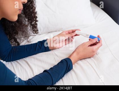 Nahaufnahme der Hände mit positivem Schwangerschaftstest mit zwei rosa Linien Stockfoto