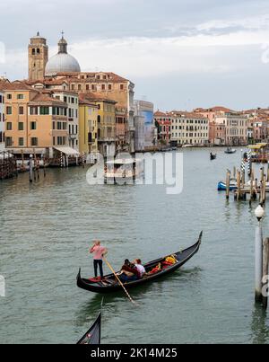 Touristen, die mit Gondeln, typischen Booten, in der Stadt Venedig, Italien, reisen Stockfoto