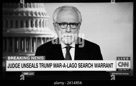 Ein TV-Screenshot des CNN-Nachrichtenanlegers Wolf Blitzer, der über Entwicklungen bei der FBI-Suche nach Donald Trumps Haus in Florida berichtet. Stockfoto