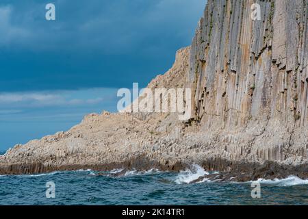 Küste der Insel Kunashir am Kap Stolbchaty mit basaltsäulen Felsen bei bewölktem Wetter Stockfoto