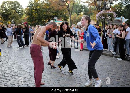 Odessa, Ukraine. 15. September 2022. Man sieht, wie die Leute zur Straßenmusikkapelle tanzen. Trotz der umfassenden Invasion der Russischen Föderation, an den Wochenenden, Freude und Leben herrschen auf der Hauptstraße von Odessa - Deribasovskaya, Urlauber gehen, tanzen, Spaß haben, wie in Friedenszeiten. Deribasovskaya Straße - eine der zentralen Straßen der Stadt Odessa, ist eine der wichtigsten Sehenswürdigkeiten der Stadt.seit dem Ende des 20.. Jahrhunderts, die meisten von Deribasovskaya wurde für den Verkehr gesperrt und ist eine Fußgängerzone. Deribasowskaja ist ein beliebter Ort für Feste. Es gibt zahlreiche Cafés und Geschäfte auf Stockfoto