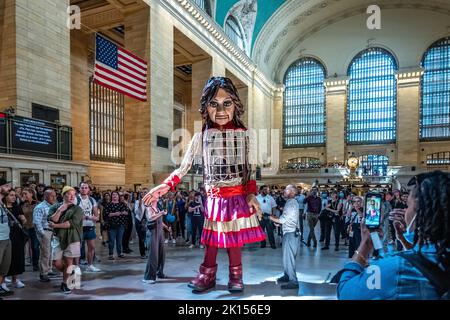 New York, USA. 15. September 2022. Die kleine Amal, eine 12 Meter hohe riesige Marionette, die einen 10-jährigen syrischen Flüchtling darstellt, wird von Menschen umgeben, als sie in New Yorks Grand Central Station ankommt. Die kleine Amal, ein Symbol für die Kämpfe von Flüchtlingen weltweit, begann ihre Reise von der syrisch-türkischen Grenze im Juli 2021 und ist nun vor der Generalversammlung der Vereinten Nationen nächste Woche in New York angekommen. Kredit: Enrique Shore/Alamy Live Nachrichten Stockfoto