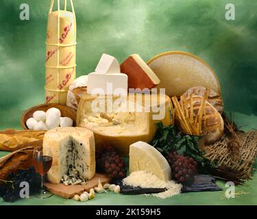 Italienischer Käse in Gruppenfoto, malerischer Filter angewendet. Grün getönter melierter Hintergrund. Studio-Tischplatte, klassisches Bild Stockfoto