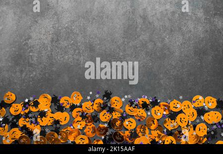 Halloween Hintergrund: Konfetti in Form von orangefarbenen Kürbissen, schwarzen Spinnen und Sternen. Grauer Hintergrund. Speicherplatz kopieren. Stockfoto