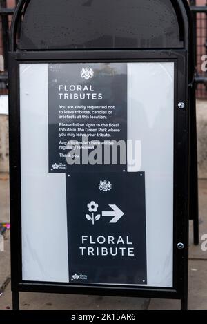 Blumen und Botschaften, die nach dem Tod von Königin Elizabeth II. Vor dem Buckingham Palace hinterlassen wurden Schild, auf dem die Besucher informiert werden, Blumen im Green Park zu hinterlassen Stockfoto