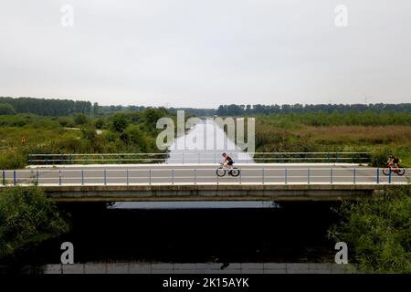 Drohnenschuss eines Radfahrers auf einer Brücke Stockfoto