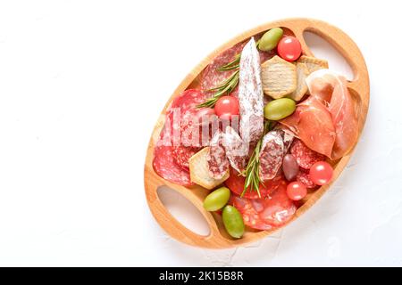 Traditionelle italienische Küche - Antipasti. Charcuterie-Tafel mit verschiedenen Wurstsorten - Salami, bresaola, Proscuitto serviert mit Oliven auf weißem Ta Stockfoto