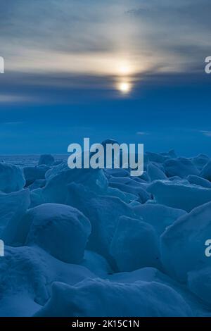 Das Winterlicht am späten Nachmittag knackt die Ränder des Eises, das in einem Eisschub an der grünen Bucht am Ufer des Lake Michigan vom Peninsula State Park, Doo, umgedreht wurde Stockfoto