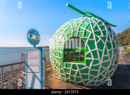 kyushu, japan - 10 2021. dezember: Metalltafel der Bushaltestelle Hirahara auf dem Highway 207 der Stadt Konagai vor der berühmten riesigen Cantaloupe frui Stockfoto