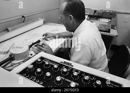 Computergesteuerte Kartengestaltung. Eine Zeichnungsmaschine wendet Konturerhöhungen auf eine neu entwickelte Karte des Staates Arizona an. 1978. Stockfoto