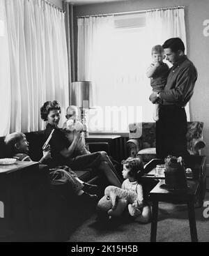 Ein kleiner Junge verhöhnt seine Familie mit einer Spielzeugwaffe. Ca. 1959. Stockfoto