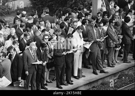 Penn Central Pendler warten auf einem überfüllten Bahnsteig in Scarsdale, New York, um 1976. Der größte Teil der Menge ist weiß und männlich, während die Zahl der Frauen bei 7 der hier gezeigten Pendlermitarbeiter rund 1 beträgt. Stockfoto