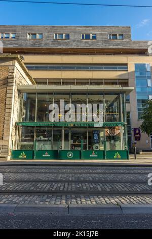 Ein gemütliches Eckcafe und Straßenbahnlinien in den Dublin Docklands, Irland. Stockfoto