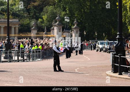 Polizeibeamter, der vor dem Buckingham Palace steht und die Öffentlichkeit und den Palast wenige Tage nach dem Tod von Königin Elizabeth II. Schützt Stockfoto