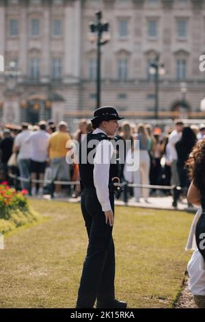 Polizeibeamter, der vor dem Buckingham Palace steht und die Öffentlichkeit und den Palast wenige Tage nach dem Tod von Königin Elizabeth II. Schützt Stockfoto