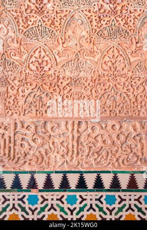 Bunte Mosaikfliesen bilden geometrisches Ornament unter arabischer Inschrift an der Wand des alten Palastes der Alhambra Festungsanlage in Granada, Spanien Stockfoto