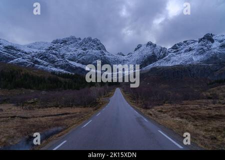 Malerische Aussicht auf leere Bergstraße im Winter unter bewölktem Himmel in Norwegen Stockfoto