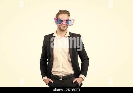 Nerdy extravagant Mann Mitarbeiter lächeln in lustige Gläser und formelle Anzug stehen, Nerd Stockfoto