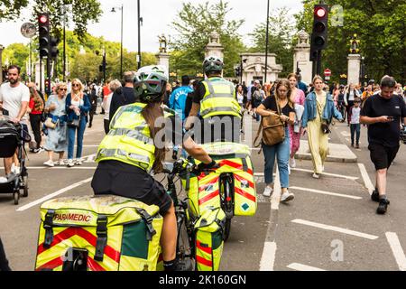 Sanitäter auf dem Fahrrad, der durch die Fußgängermassen in der Nähe des Buckingham Palace navigiert Stockfoto